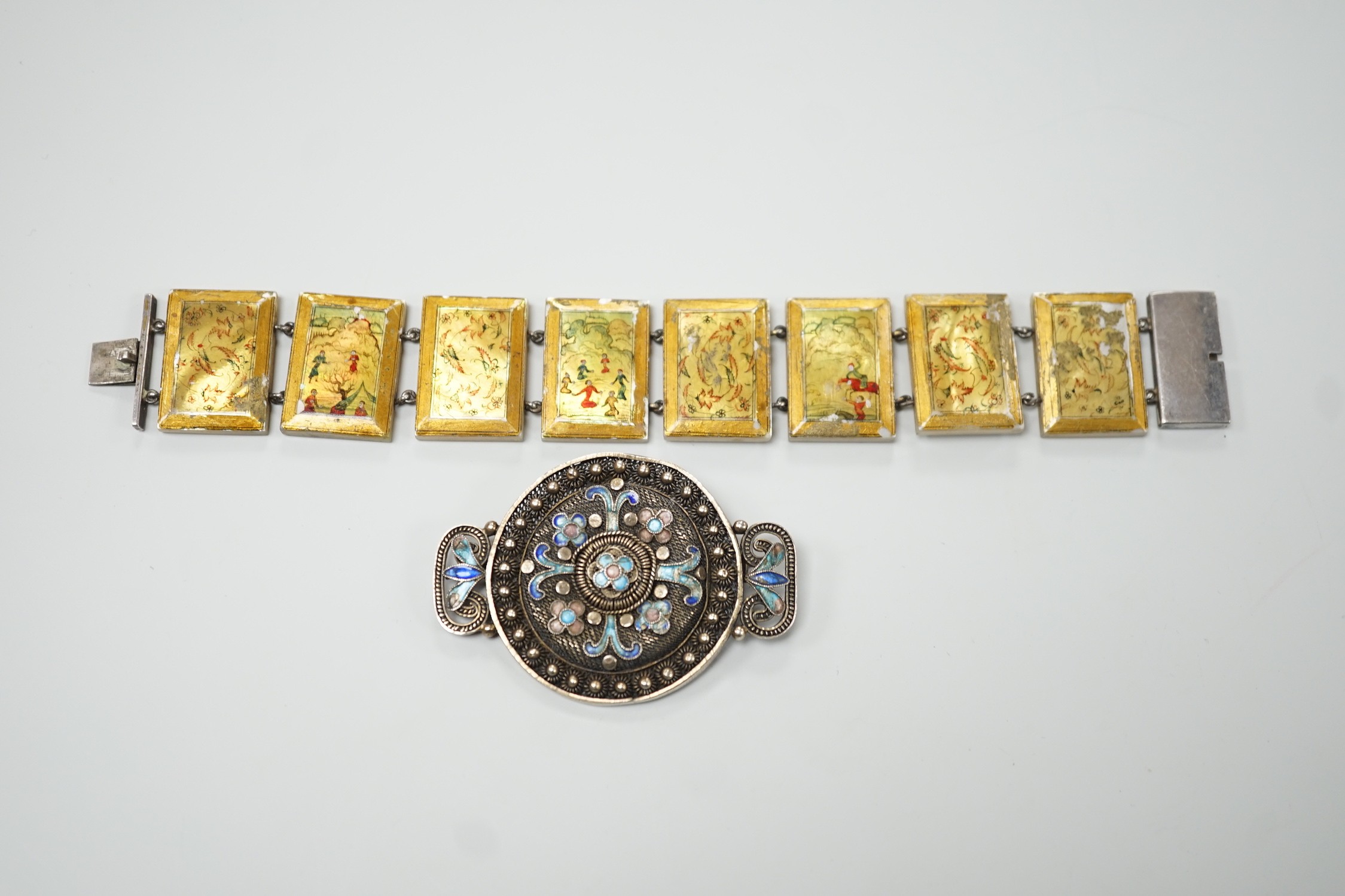 A Persian lacquered mother of pearl panel bracelet, 17cm and a Chinese filigree white metal and 'kingfisher' enamelled brooch, 54mm.